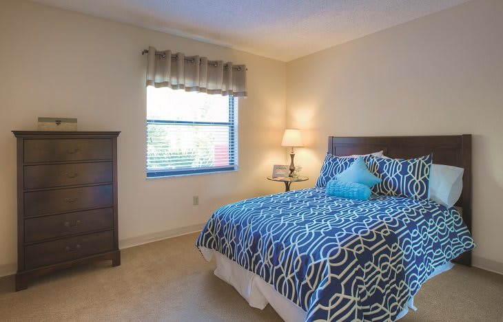 A cozy bedroom with a patterned bedspread and soft lighting.