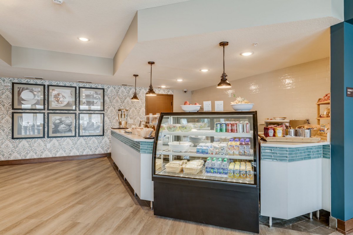 A modern cafe interior with a display case and seating area.