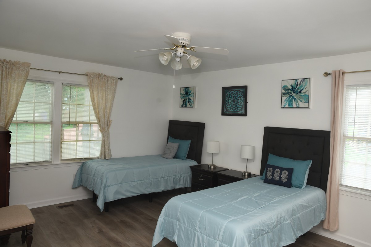 A cozy bedroom with two twin beds, featuring elegant decor and soft lighting.