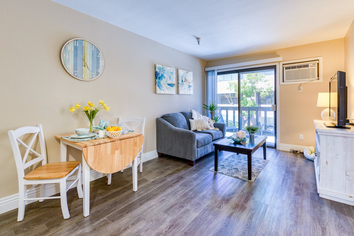 A cozy living room with modern furniture, featuring a dining table and sofa.