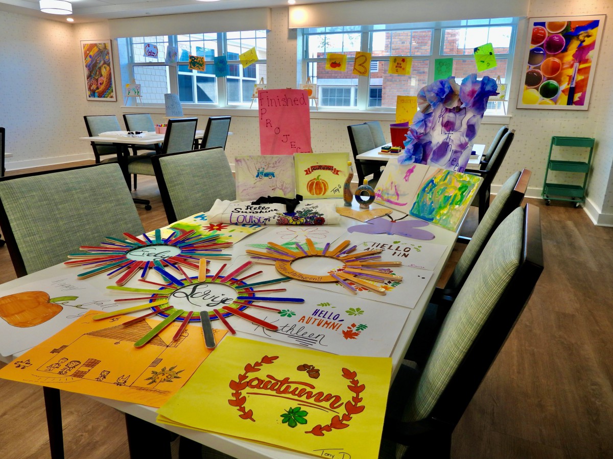 A table adorned with colorful handmade art and craft projects in a bright room.