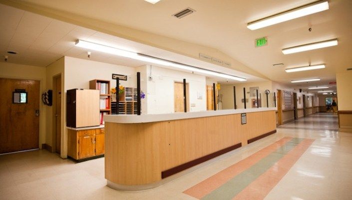 A hospital reception area with a desk and corridor.