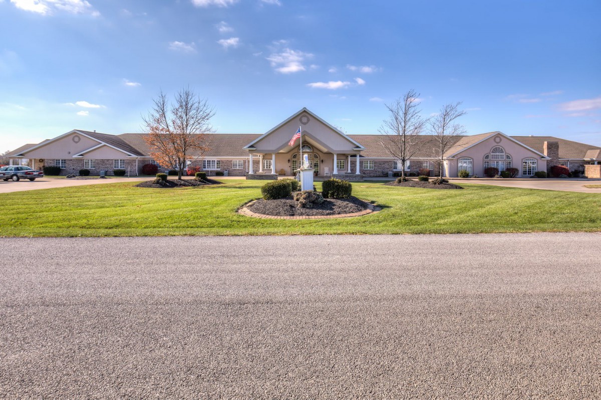 A suburban residential building with a well-maintained lawn and clear blue skies.