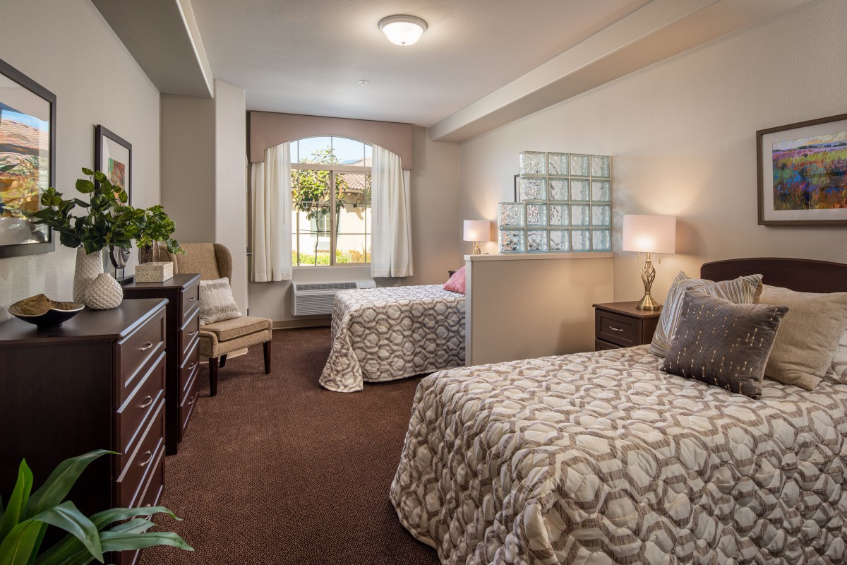 A cozy bedroom with twin beds and a large window.