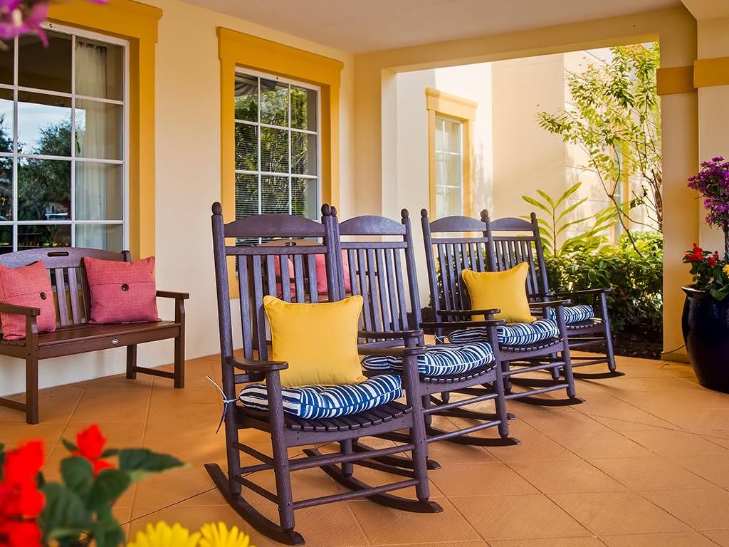 A cozy porch with wooden rocking chairs and colorful cushions, perfect for relaxation.