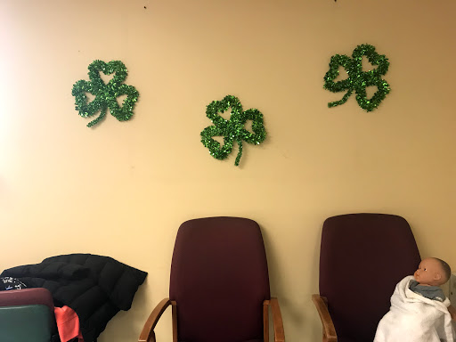 Decorative shamrocks adorn the wall above empty chairs.