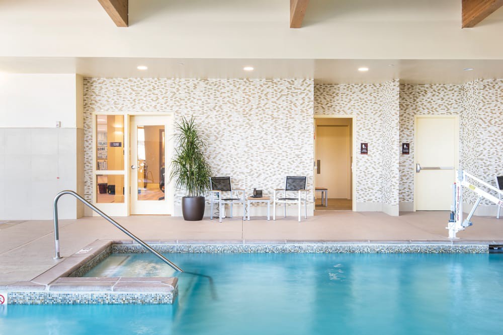 A serene indoor pool area with adjacent seating and modern decor.