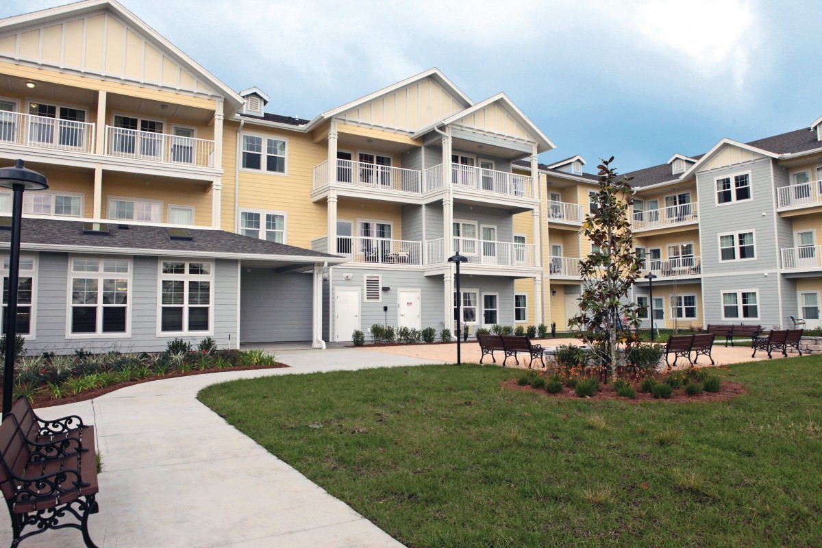 A modern multi-story apartment building with balconies and well-maintained landscaping.
