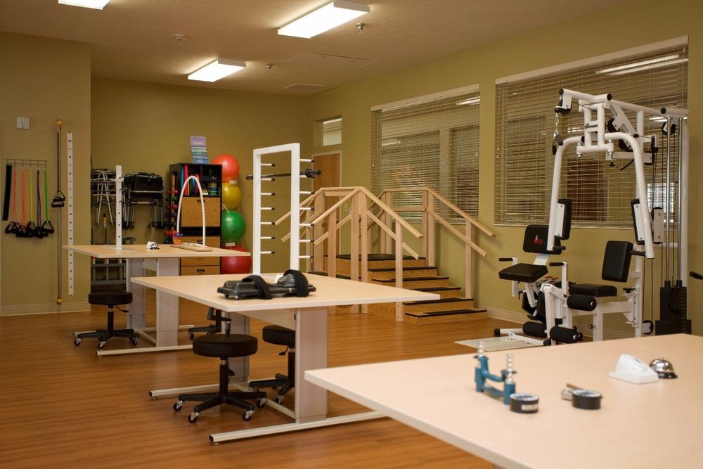 A well-equipped physical therapy room with various exercise and rehabilitation equipment.