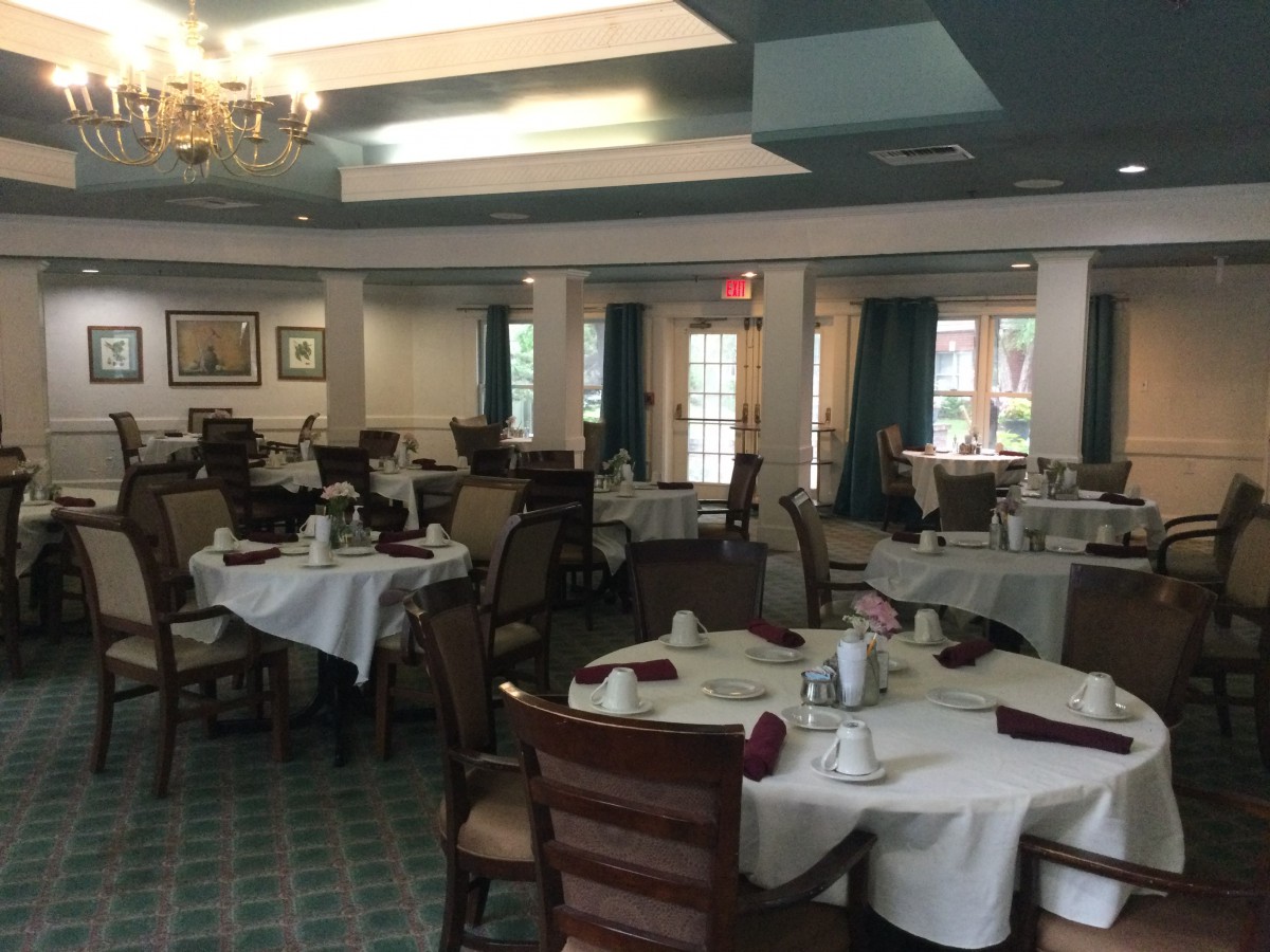 An empty dining room with neatly arranged tables and chairs, ready for service.