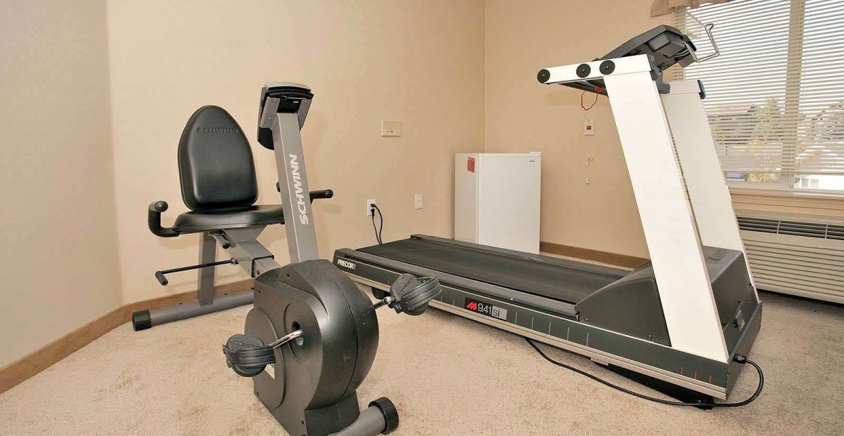A small indoor gym with a treadmill and stationary bike.