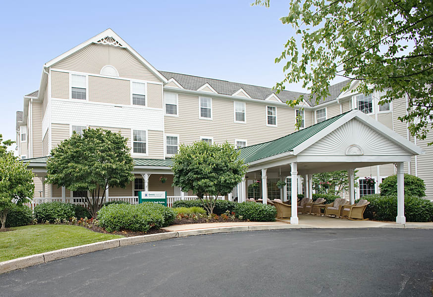The exterior view of a hotel with a covered entrance and landscaped surroundings.