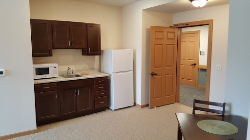 A cozy kitchen space featuring wooden cabinets, a refrigerator, and an inviting atmosphere.