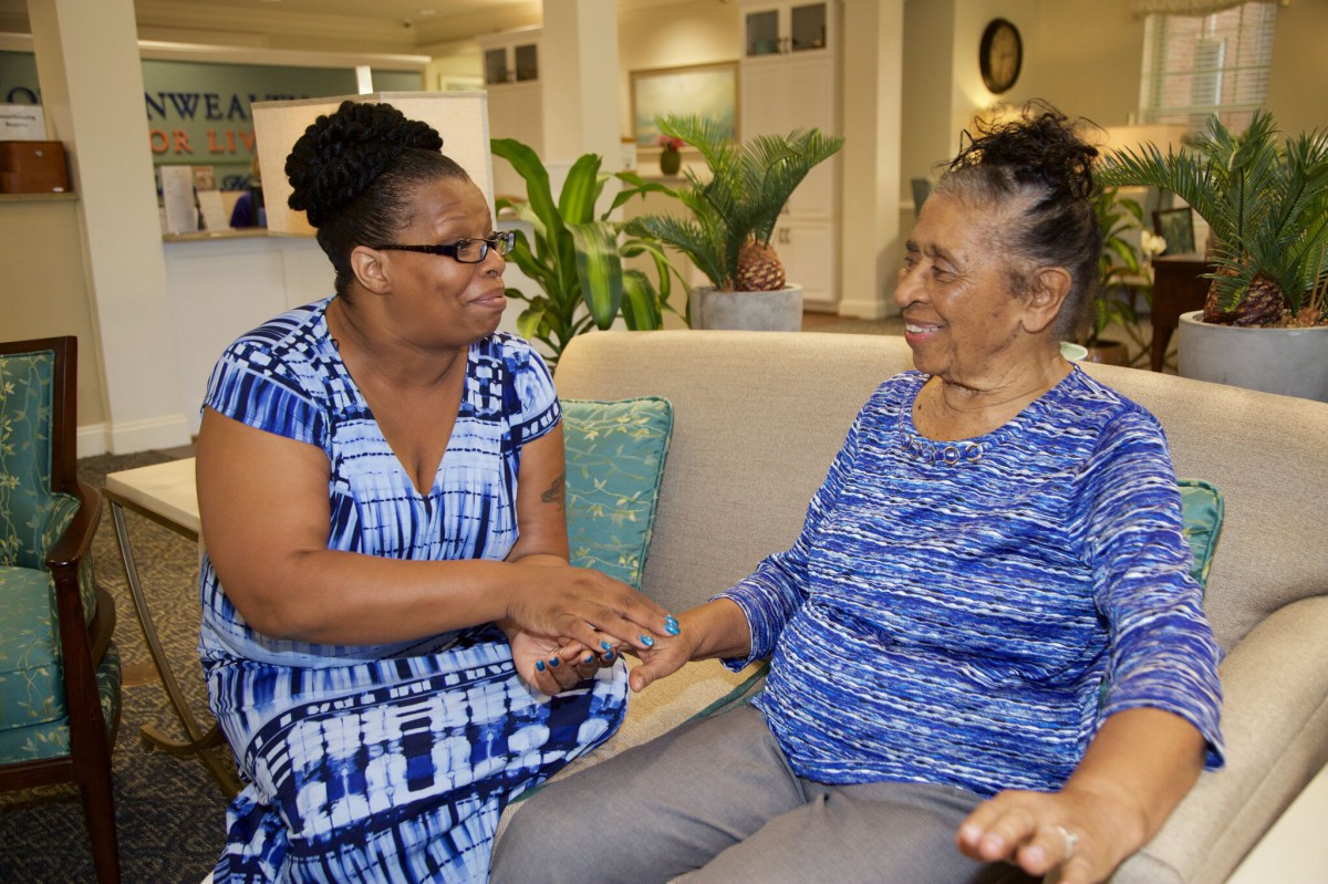 Two women sharing a supportive moment in an indoor setting.