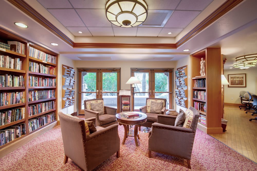 A cozy reading nook in a library with comfortable chairs and bookshelves.