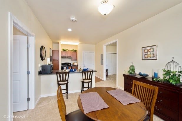 A cozy dining area with a round table and a view into the kitchen.