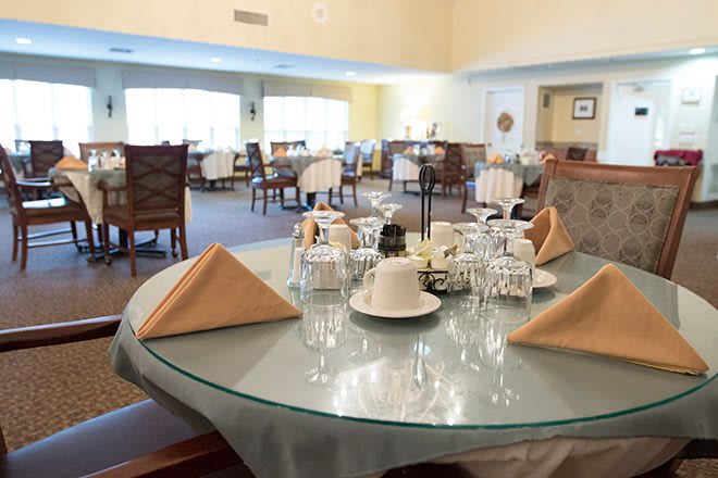 A well-set dining table in a spacious restaurant interior.