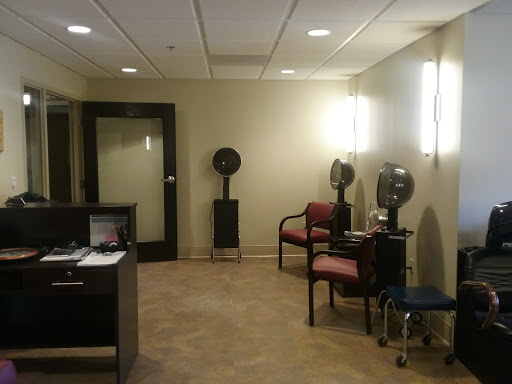 A cozy waiting area in a modern salon, featuring chairs and hairdryers.