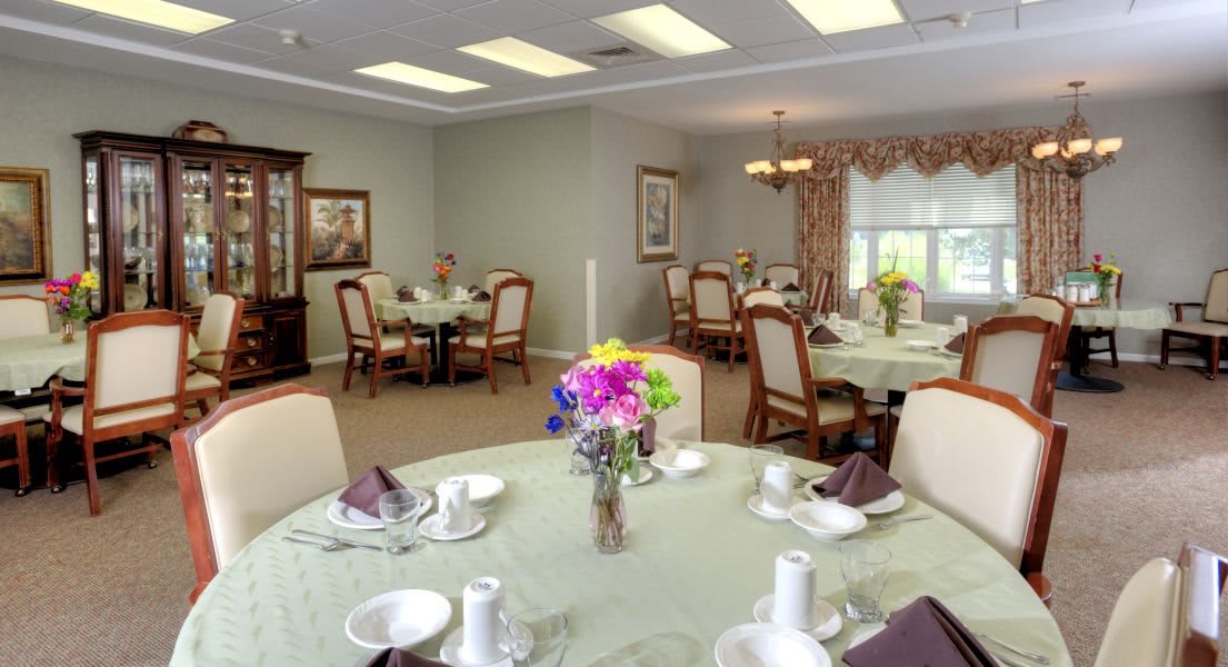 A well-decorated dining room with elegant table settings and floral centerpieces.