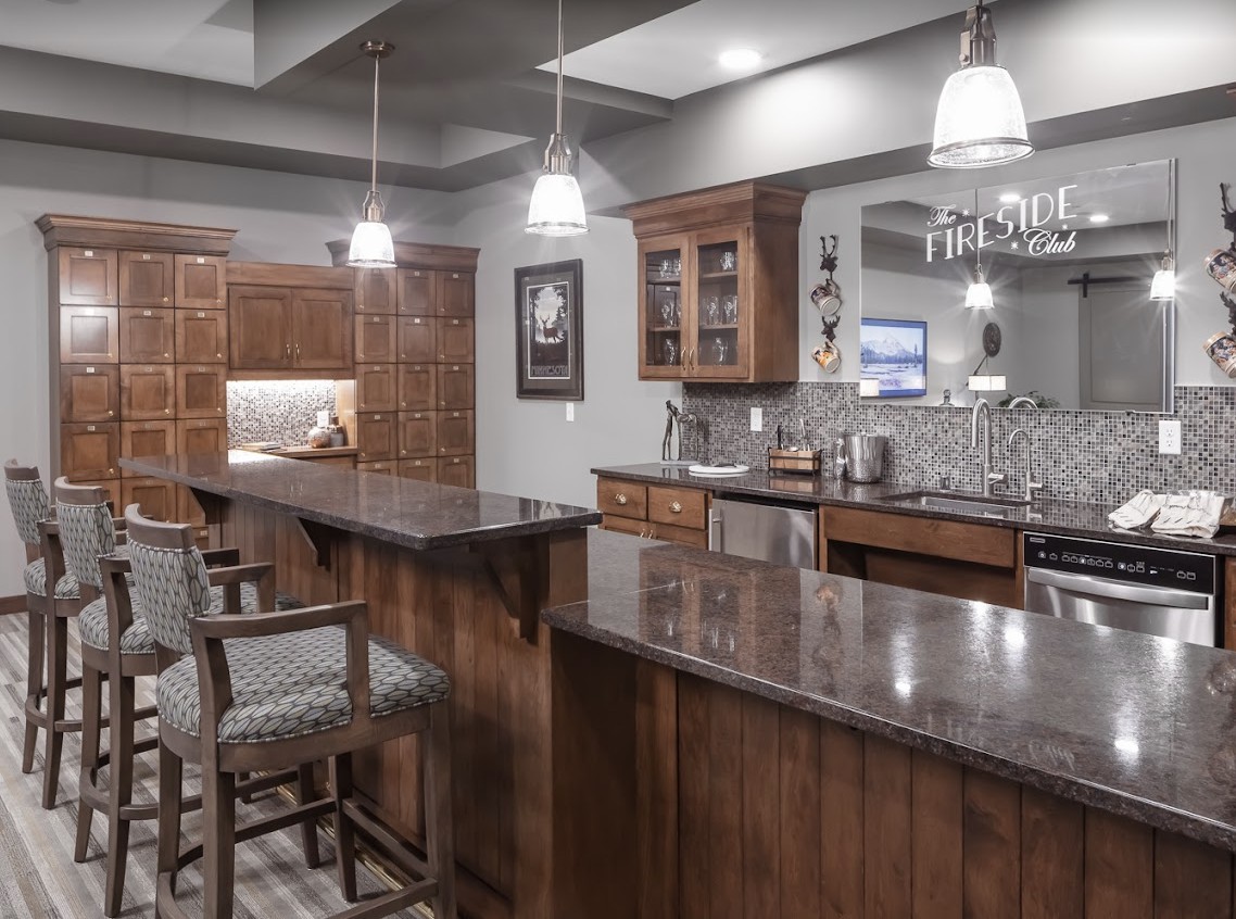 A modern home bar with wood cabinetry and stylish lighting.