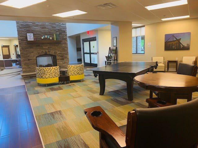 A modern lounge with seating and recreational amenities, featuring a pool table and comfortable chairs.