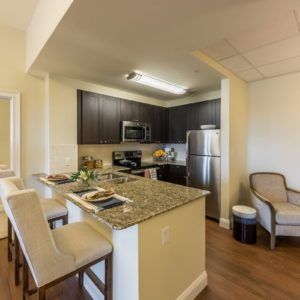 A modern kitchen with a granite countertop and stainless steel appliances.