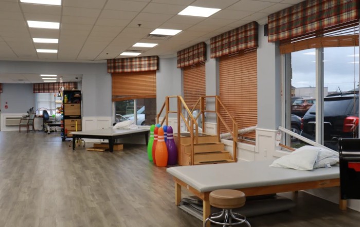 A rehabilitation clinic equipped with therapy beds and exercise equipment.