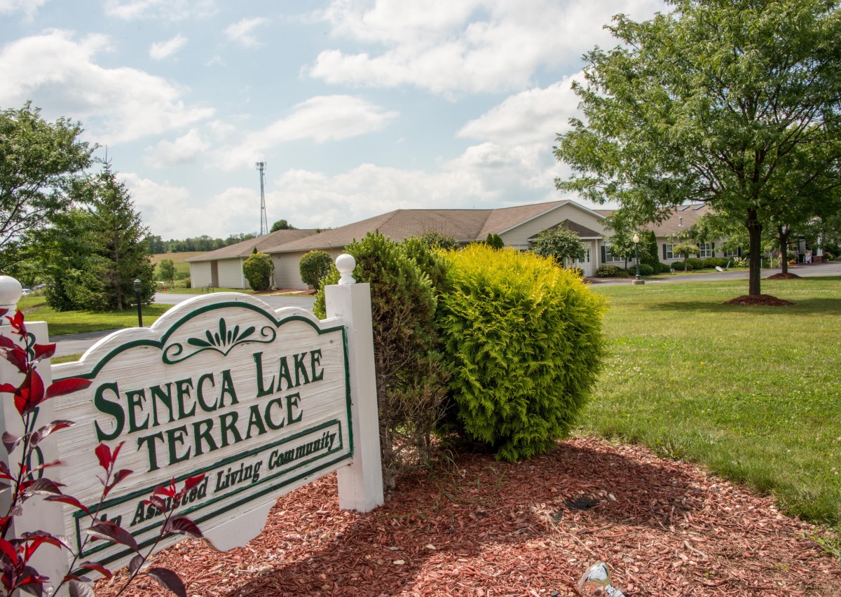 Seneca Lake Terrace assisted living community sign surrounded by greenery and a well-maintained landscape.