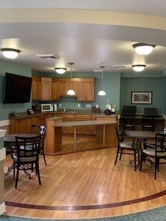 A cozy kitchen and dining area with wood flooring and modern lighting.