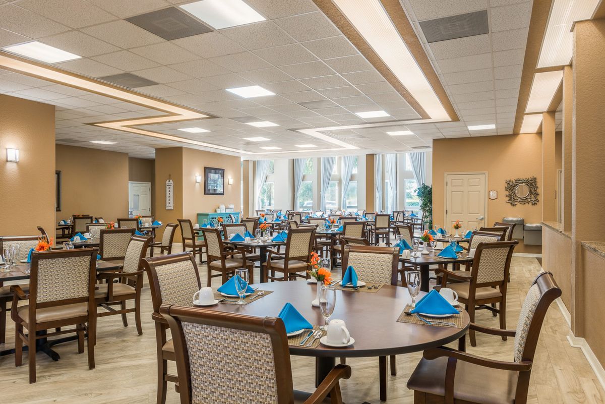 An elegantly set dining room with tables prepared for guests.