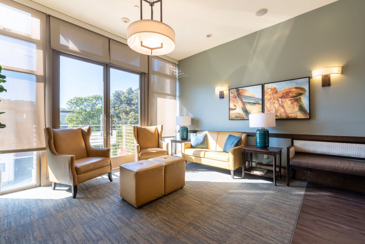 A modern living room with ample natural light, featuring comfortable seating and elegant decor.