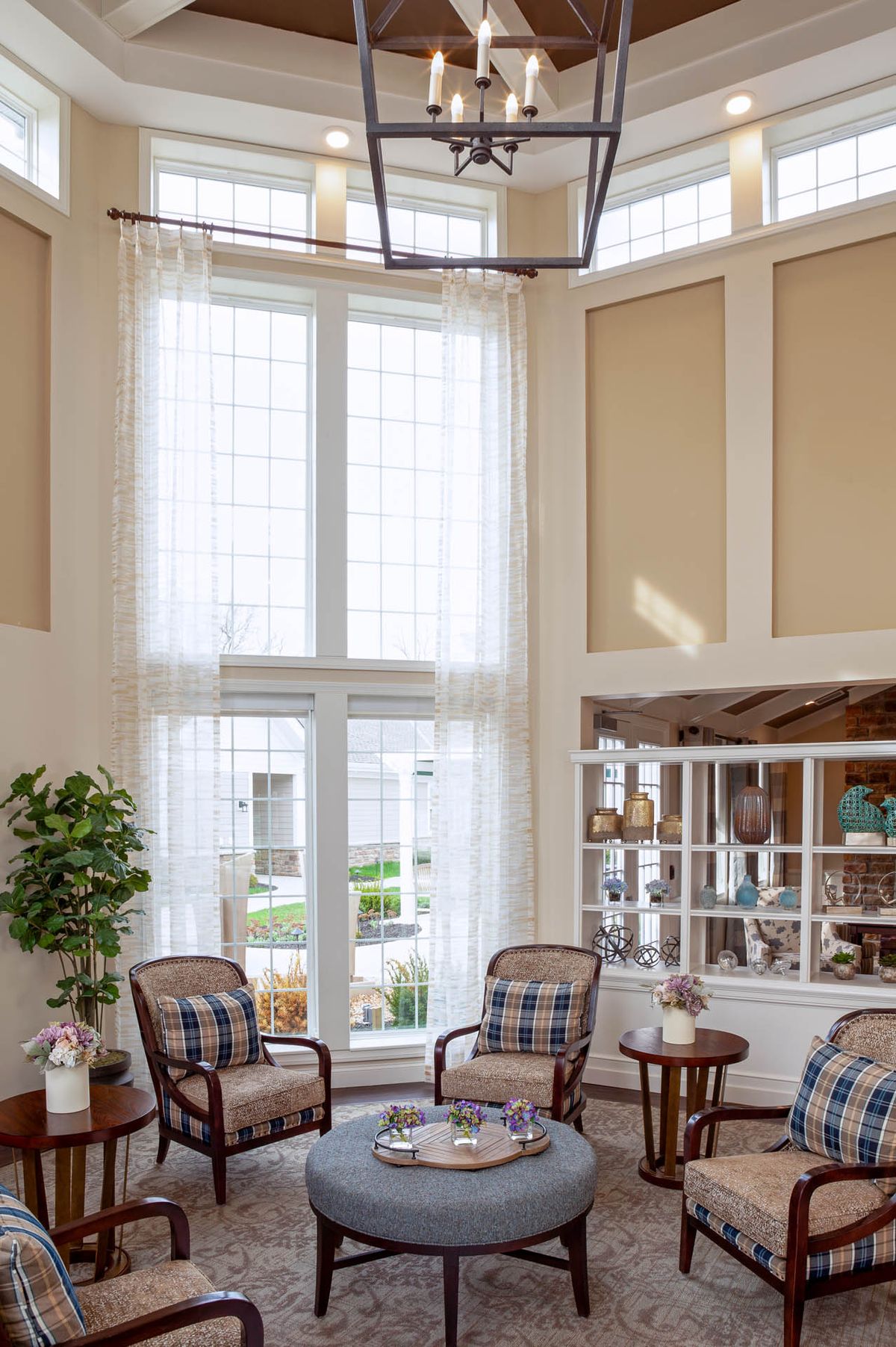 A bright, elegantly furnished living room with large windows and comfortable seating.