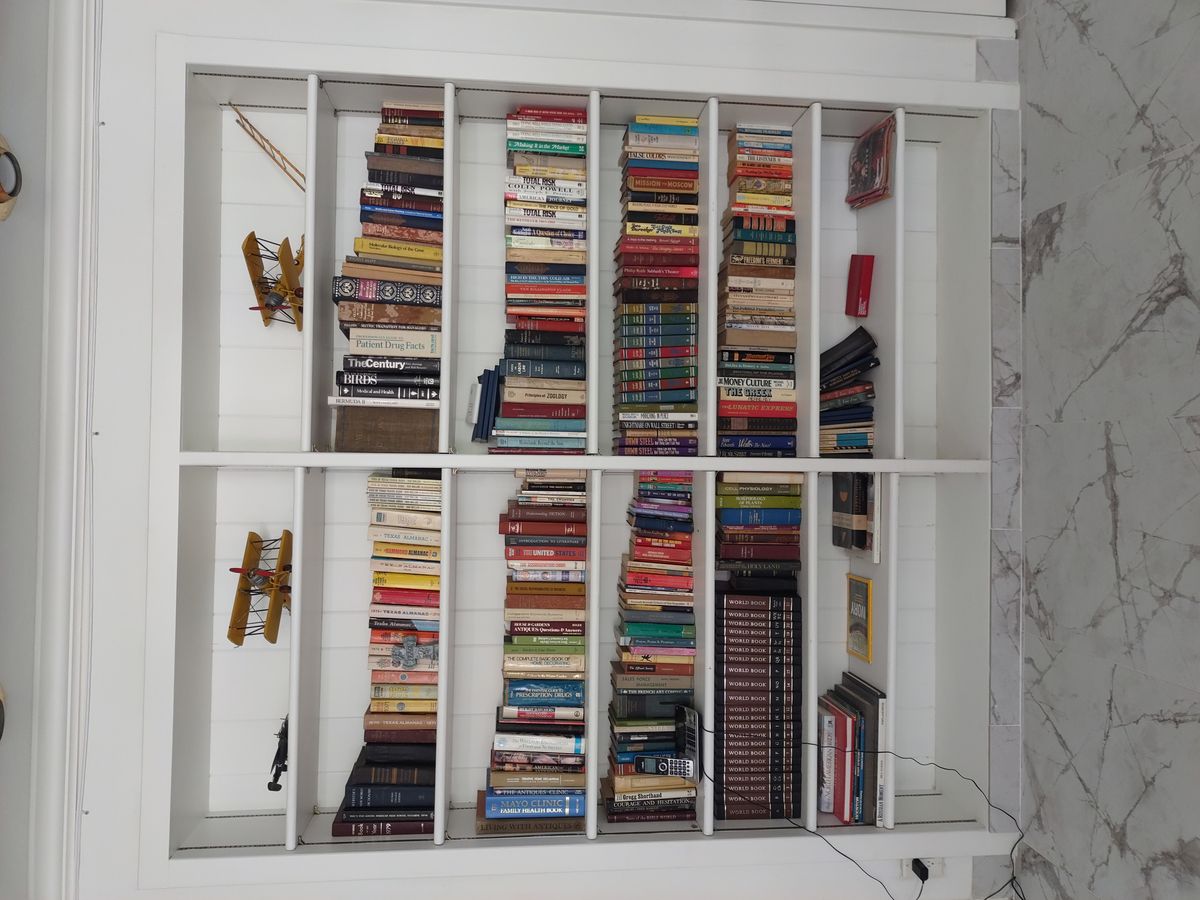 A well-stocked bookshelf filled with a diverse collection of books.