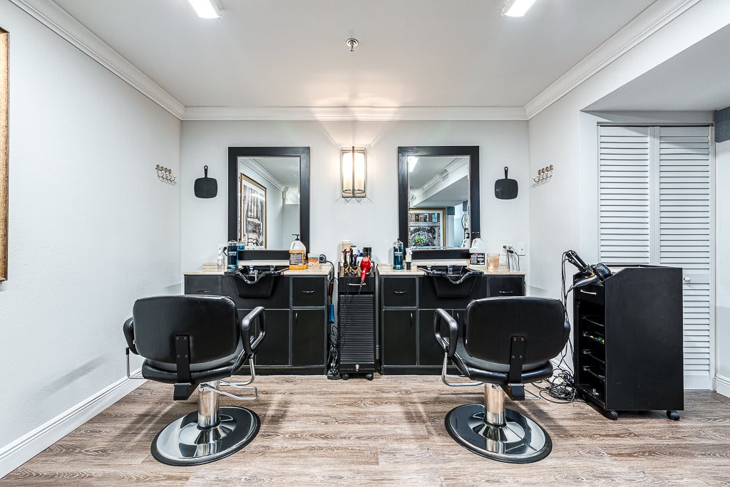 A modern barber shop interior with two styling stations and chairs.