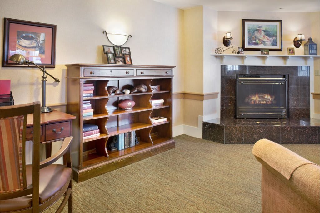 A cozy living room with a wooden bookshelf and a fireplace.