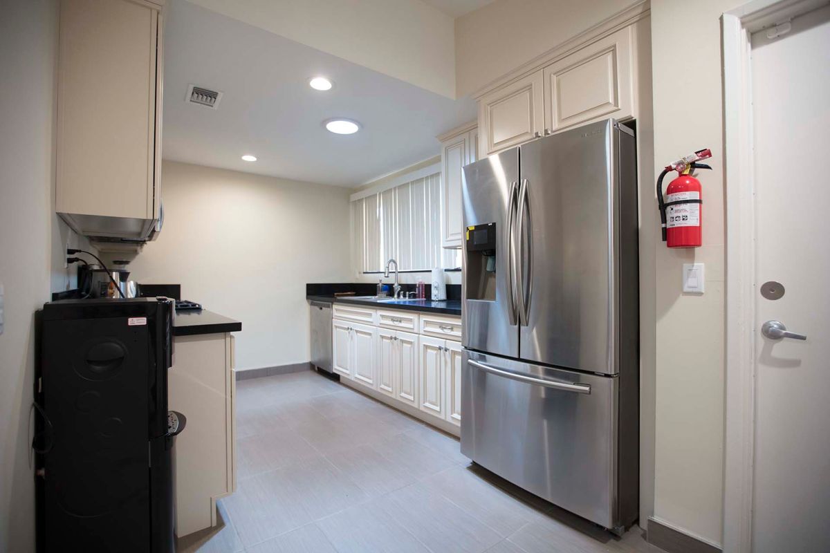 A modern kitchen featuring stainless steel appliances and white cabinetry.