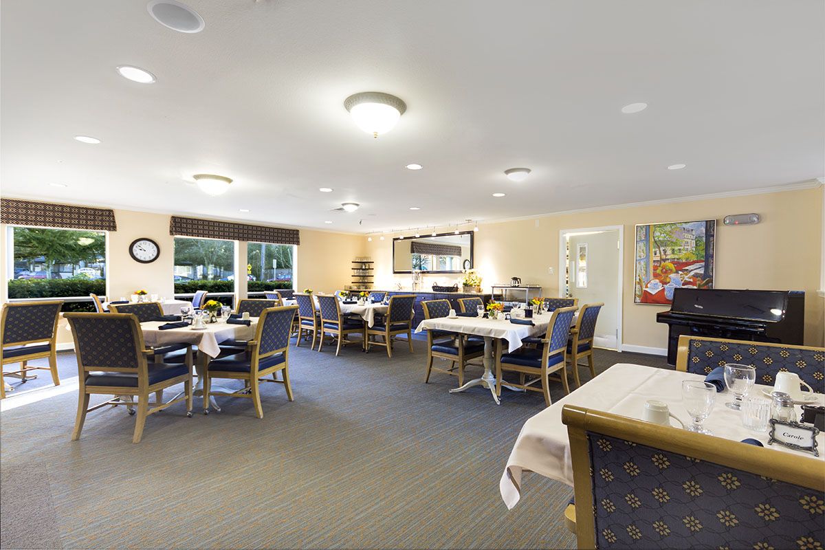 A well-lit dining area with neatly arranged tables and chairs.