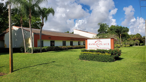 A well-maintained building with vibrant landscaping under a cloudy sky.