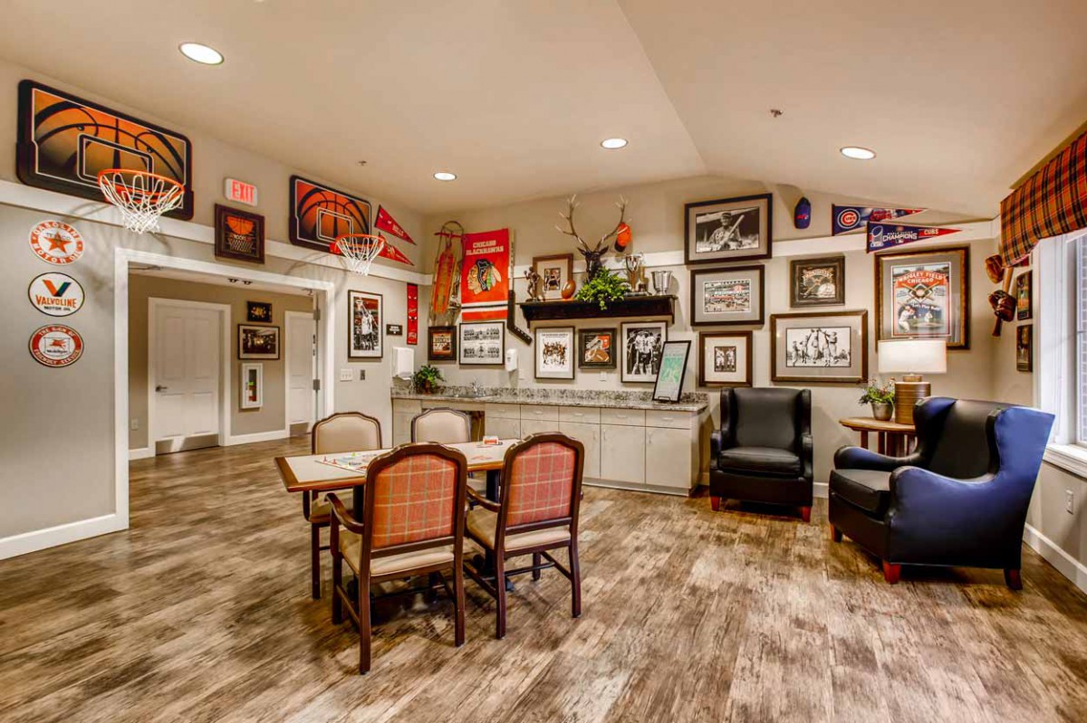 A cozy room with a gallery wall filled with various framed artworks and photos, along with comfortable seating and wooden flooring.
