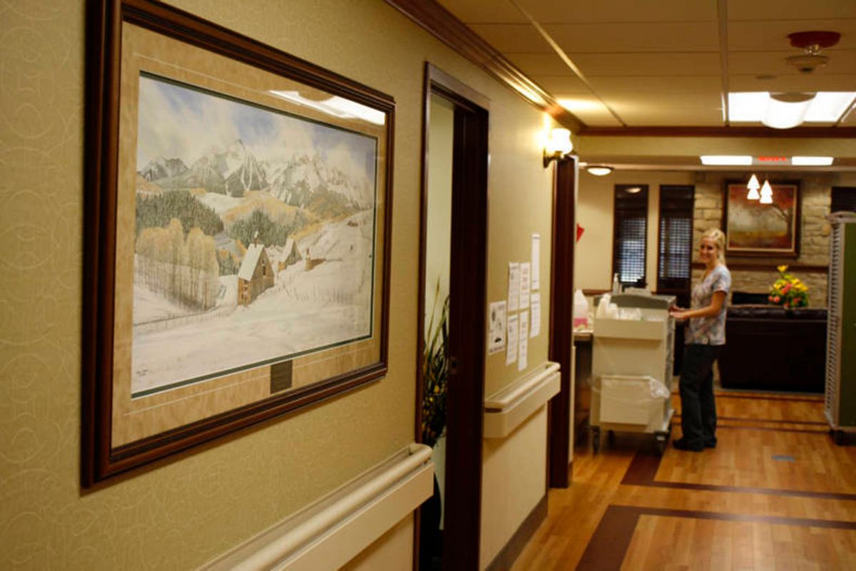 A hospital hallway featuring a landscape painting on the wall.