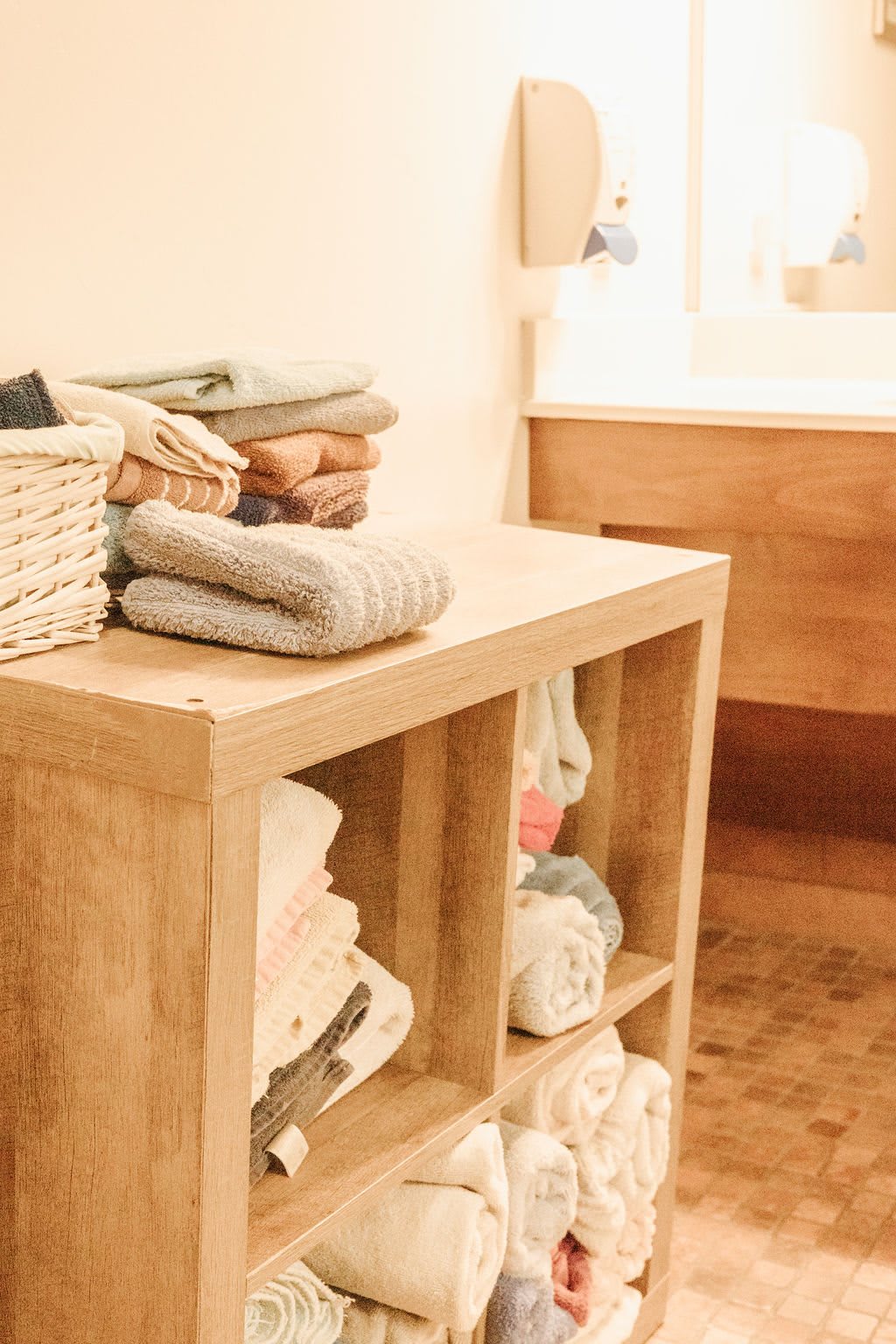 A neatly organized laundry room with folded towels on wooden shelves.