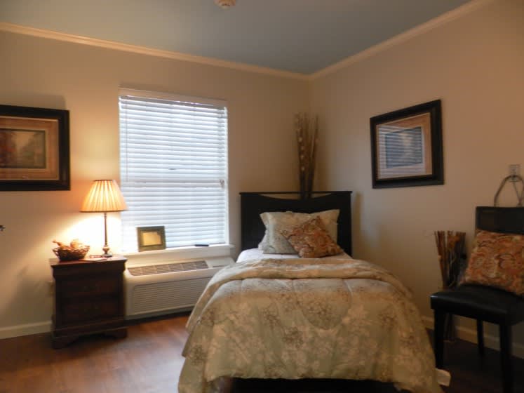 A cozy bedroom with a single bed, warm lighting, and tasteful decor.