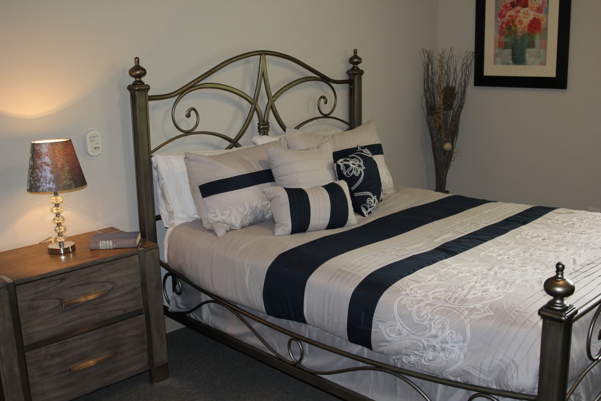 A cozy bedroom with an iron bed frame and stylish bedding.