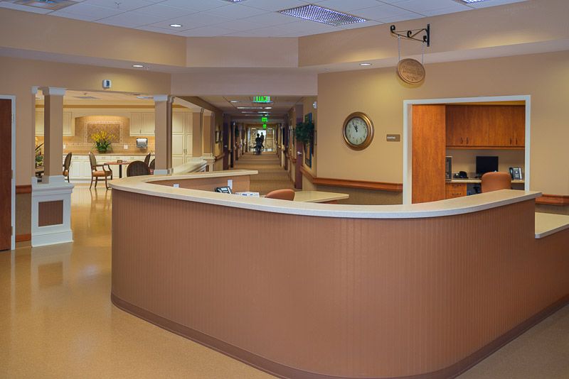A quiet hospital reception area with a hallway leading to patient rooms.