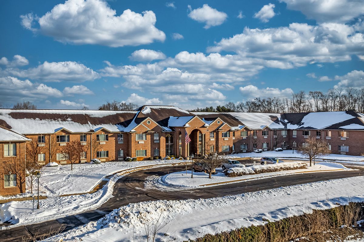 A scenic view of a building surrounded by snow under a cloudy sky.