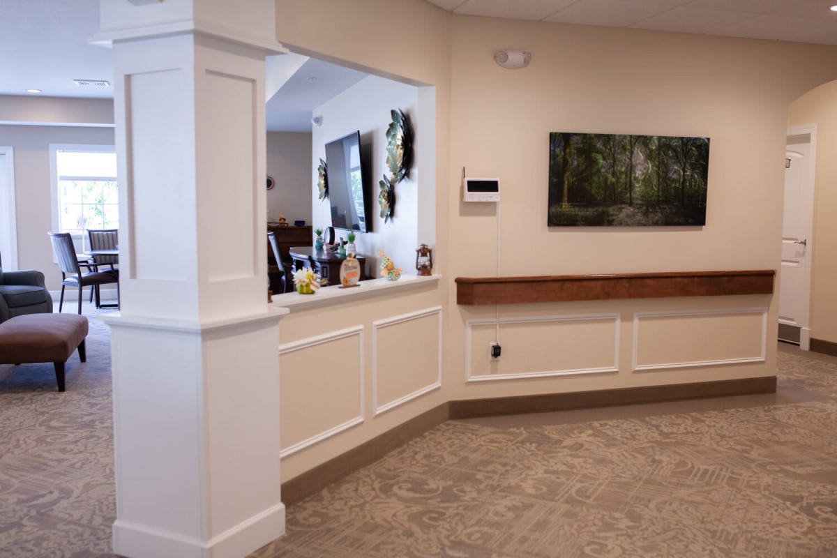 Interior view of a reception area with a counter and artwork on the wall.