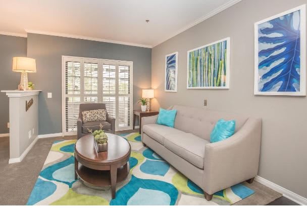 A modern living room with a cozy sofa, armchair, and vibrant decor.