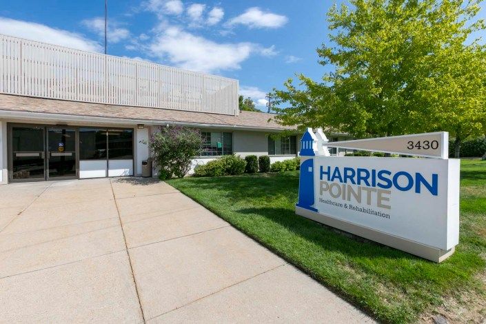 The entrance to the Harrison Pointe building, featuring clear signage and a landscaped pathway.