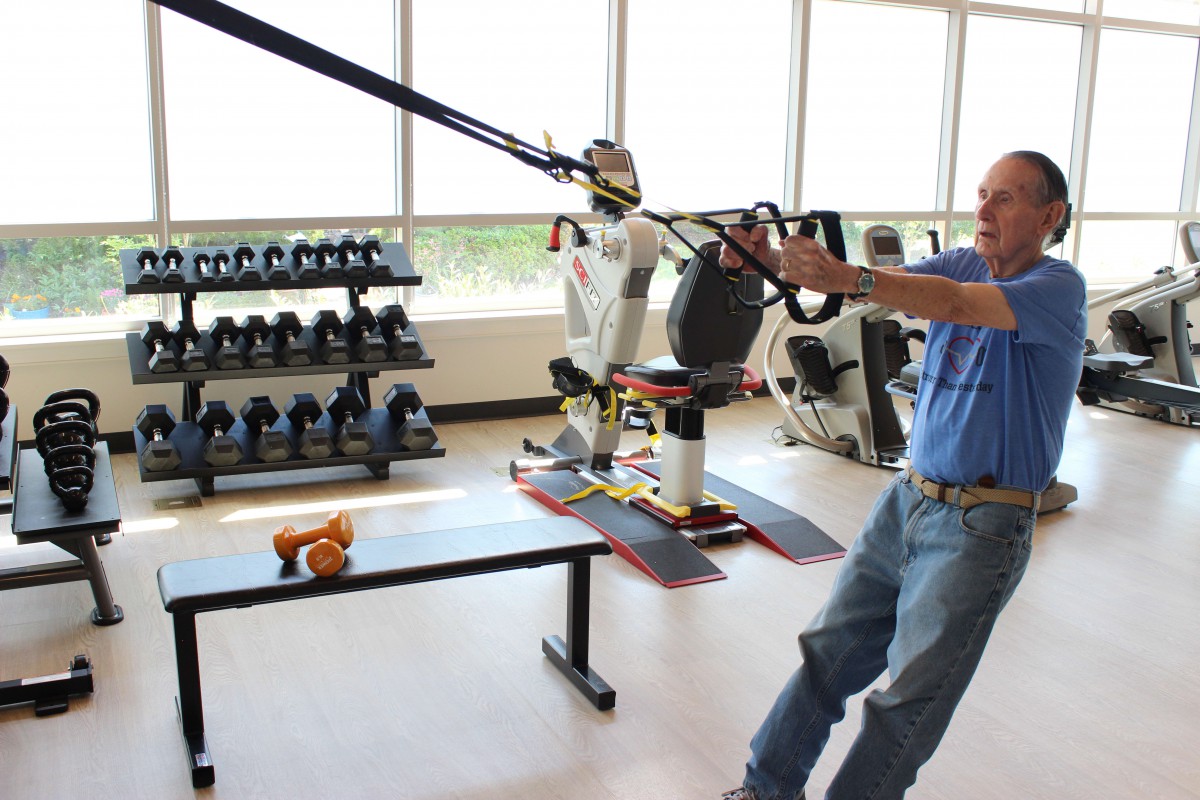 A person participating in a physical therapy session using exercise equipment in a fitness center.