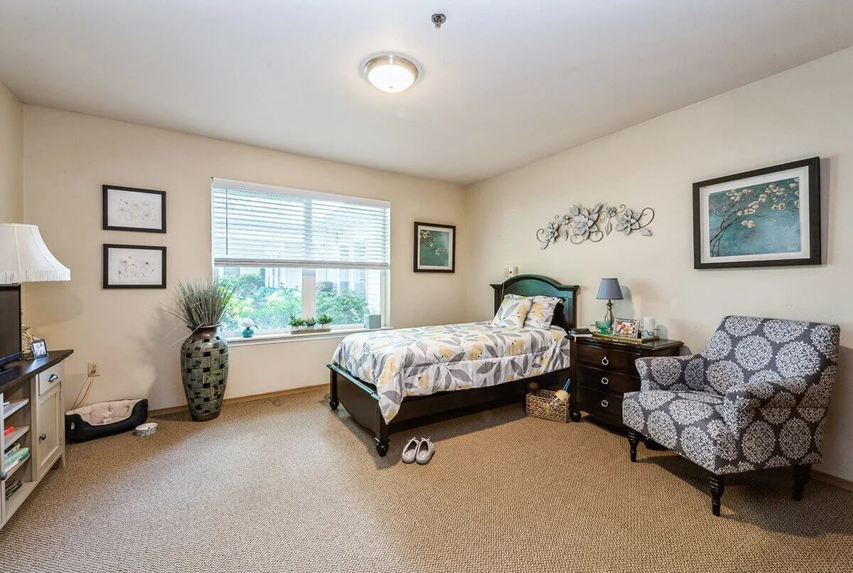 A cozy bedroom with a single bed, armchair, and decorative elements.